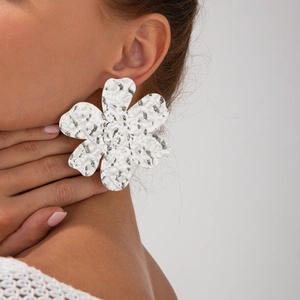Dettaglio degli orecchini a fiore in argento con petali martellati indossati