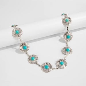 Detailed macro view of bohemian waist chain with turquoise beads and embossed silver discs