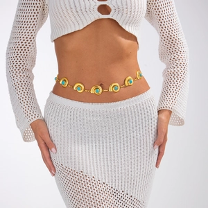 Bohemian gold waist chain with shell-style charms and turquoise stones on a model