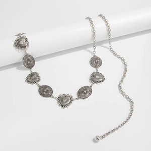 Close-up of vintage silver body chain with heart motifs and adjustable ball pendant