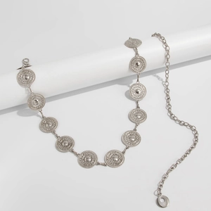 Detail of bohemian silver waist chain featuring embossed metal discs and lobster clasp