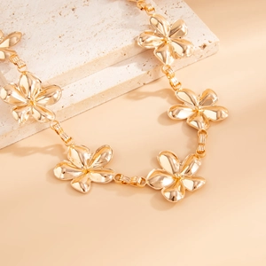 Detailed macro view of golden metal flower chain links with intricate floral textures