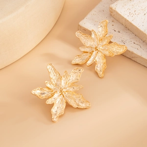 Macro detail of gold flower earrings showing liquid metal texture and wrinkled petals