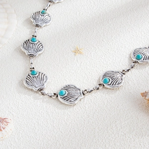 Detail of silver shell waist chain with turquoise accents and decorative sea starfish