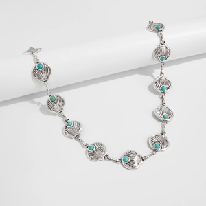 Détail de la chaîne de taille coquillage argentée avec perles turquoises style bohème