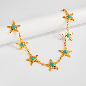Détail de la chaîne de corps étoile de mer vintage avec pierres turquoise et métal doré