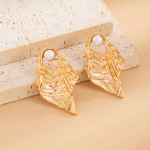 Detailed shot of golden liquid lava earrings with crushed texture and pearl accents