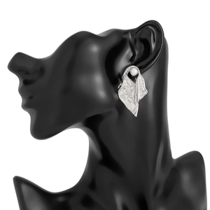 Detail of silver irregular crumpled earrings with white pearl on a dark model