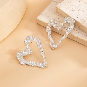 Detailed view of silver heart earrings with textured lava liquid metal surface on stone