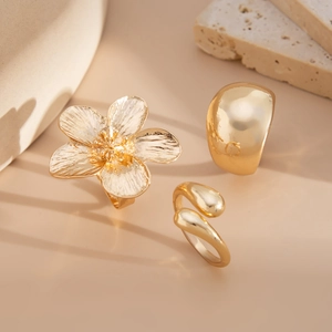 Detailed view of a 3-piece gold ring set featuring a floral design and mirror finish