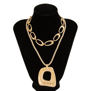 Detailansicht der doppellagigen goldenen Kreuzkette mit Gliederkette und geometrischem Anhänger