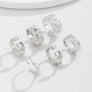 Detail of silver textured ring set with lava and hammered finish on white backdrop