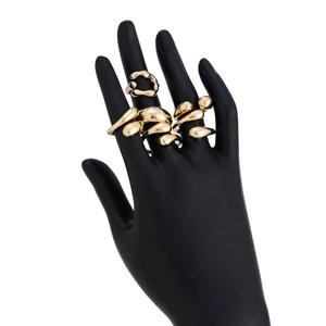 Macro shot of liquid metal style gold rings with mirror-polished irregular lava design
