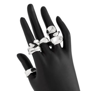 Macro view of four-piece irregular liquid metal silver ring set on a black hand model