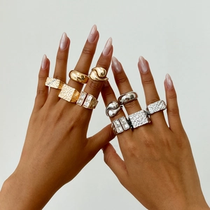 Detail of diverse stackable rings with gold and silver finish on model fingers