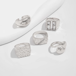 Detailed close-up of a 5-piece silver rings set with textured metal and zircon accents