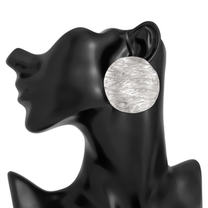 Detailed macro shot of silver lava textured round earrings on a black model silhouette