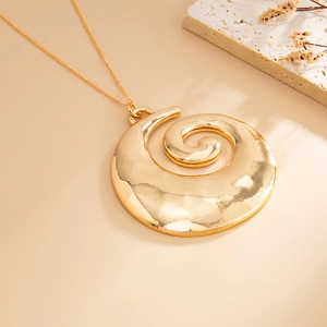 Detailed view of large golden spiral shell pendant with textured hammered metal finish
