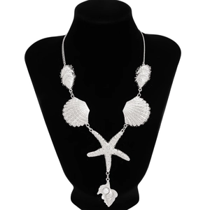 Dettaglio di una collana marina in argento con ciondoli a stella marina e perle