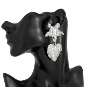 Detailed view of silver liquid lava textured heart earrings with starfish charms on model