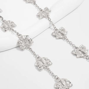 Macro di ciondoli a fiocco argentati e dettagli della catena per collana lunga elegante