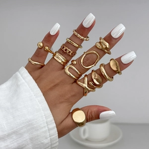 Close-up of bohemian gold ring set with diverse geometric and twisted band designs