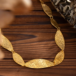 Makro-Detail der goldenen Hammerschlag-Glieder an einer geometrischen Körperkette