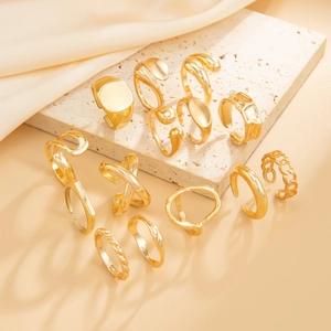 Detailed set of twelve irregular molten lava gold rings displayed on a stone pedestal