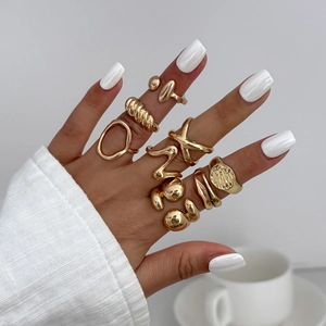 Close-up of gold liquid lava metal rings set with irregular pleated and minimalist designs