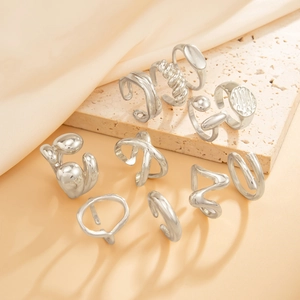 Polished silver liquid metal rings set on stone base with neutral fabric background