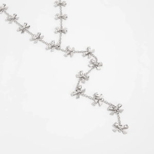 Dettaglio di elementi a fiocco in argento lucido su una collana con nappine chic