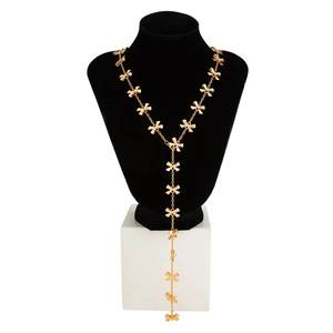 Dettaglio della collana lunga dorata a Y con ciondoli a fiocco 3D su espositore nero
