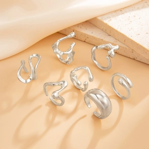 Detailed view of silver liquid metal rings with irregular organic texture on silk