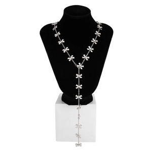 Dettaglio di una collana a Y argentata con fiocchi e lunghe frange su un busto nero