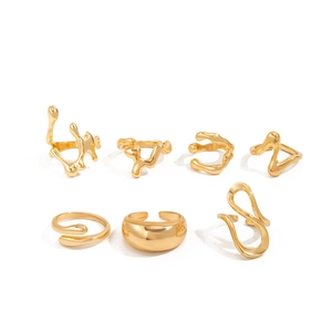 Macro detail of 7-piece gold irregular liquid metal ring set with organic fluid texture