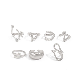 Macro shot of silver liquid metal jewelry set featuring irregular fluid rings and earrings