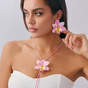 Detail of pink orchid flower necklace and earring set on model with a soft wax cord