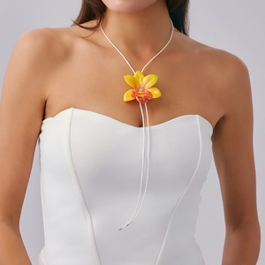 Artistic orchid flower pendant necklace with vibrant yellow gradient on a white cord strap