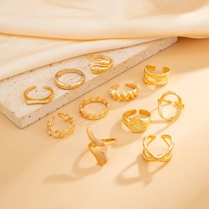 Close-up of 11-piece golden alloy ring set with hollow heart and twisted chain textures