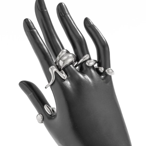 Macro view of silver lava style irregular rings featuring liquid texture on a black hand