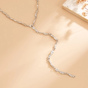 Dettaglio macro della collana d'argento con trama lavica e maglie a catena organica