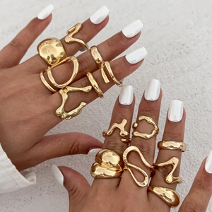 Close-up of golden lava-inspired irregular rings with high-polish mirror finish on hands