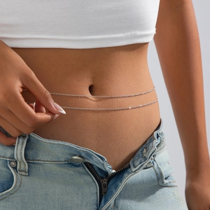 Detail of a double-layered silver flat snake chain body link on denim jeans