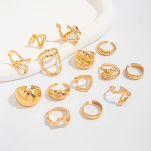 Close-up of 13-piece gold liquid lava irregular geometric ring set on white background