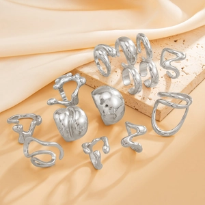 Close-up of molten lava style silver rings on travertine stone with silk backdrop