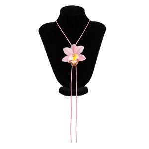 Detailed close-up of pink orchid pendant with yellow center on long cord necklace