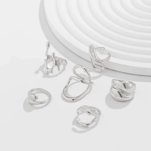 Detail view of a 6-piece silver jewelry set with irregular liquid metal drop designs