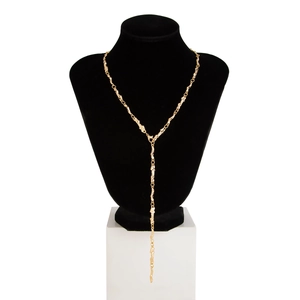 Dettaglio collana lunga a Y dorata con maglie testurizzate stile lava su busto nero
