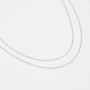 Macro detail of a minimalist silver metal flat snake chain and body chain link
