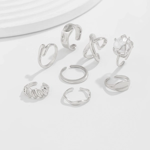 Macro detail of a 7-piece silver geometric ring set with texture and pearl accents